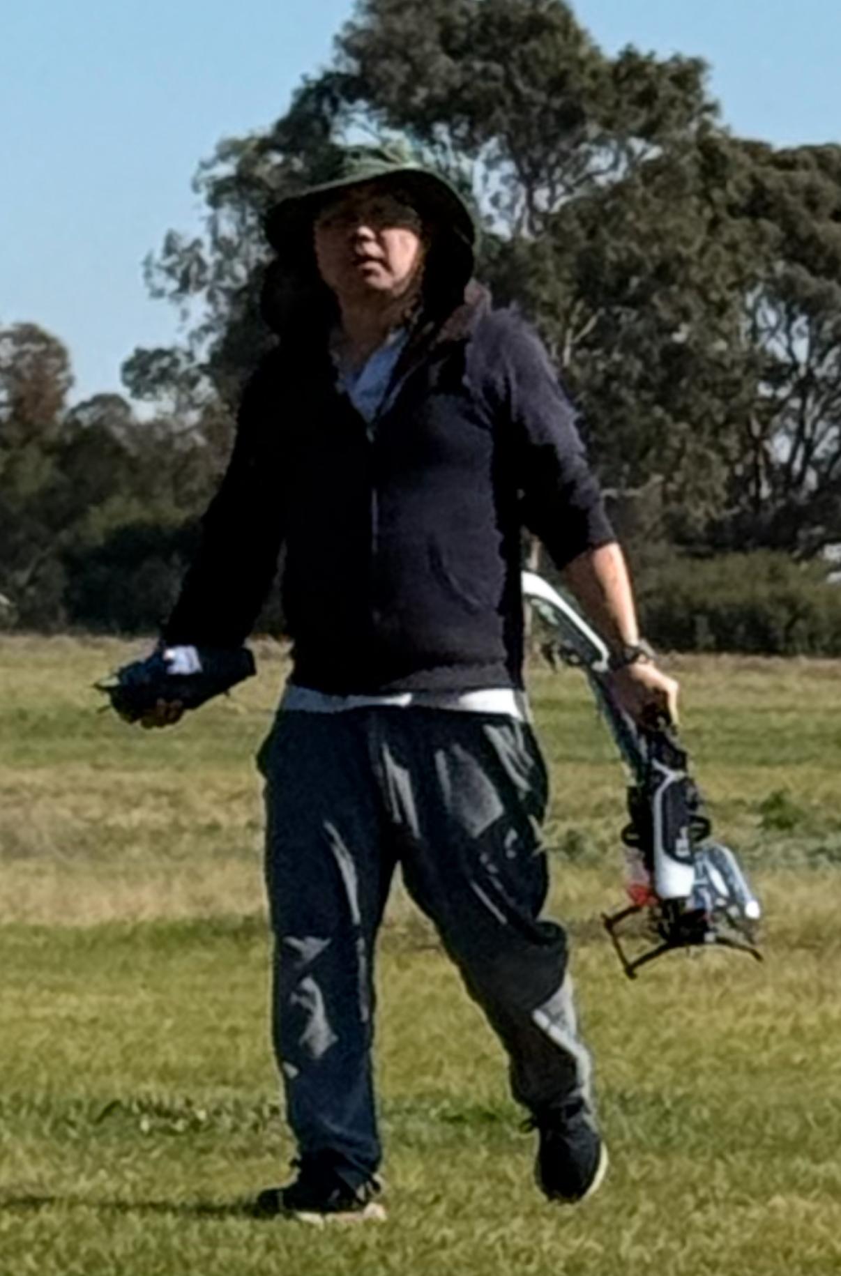 Member showing helicopter blades to children at the field
