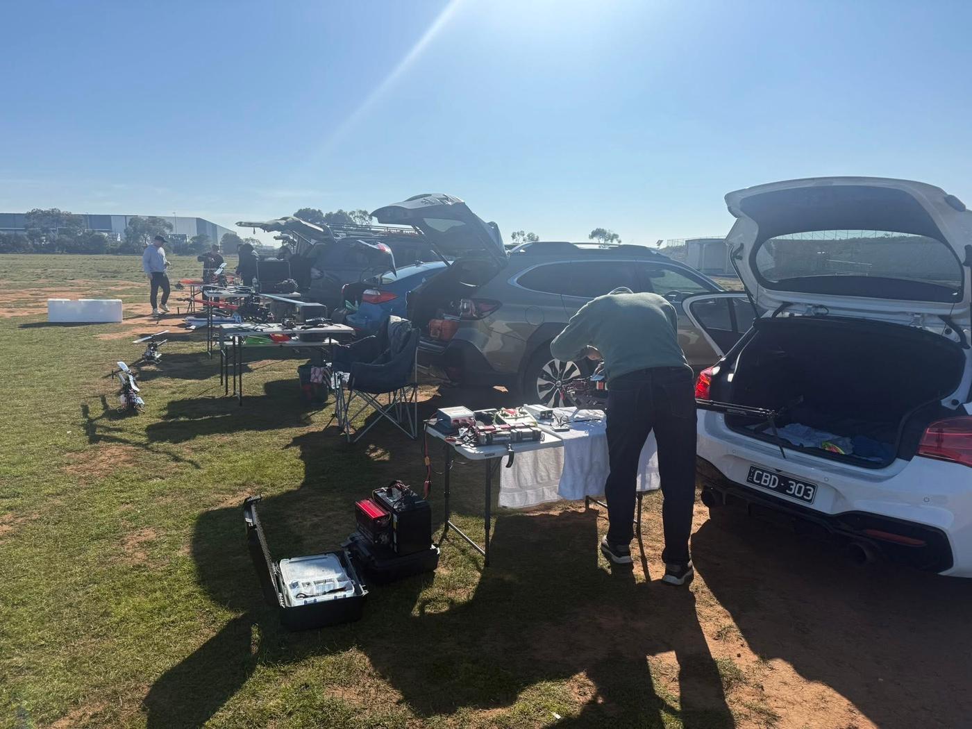 Members setting up helicopters and equipment beside their cars