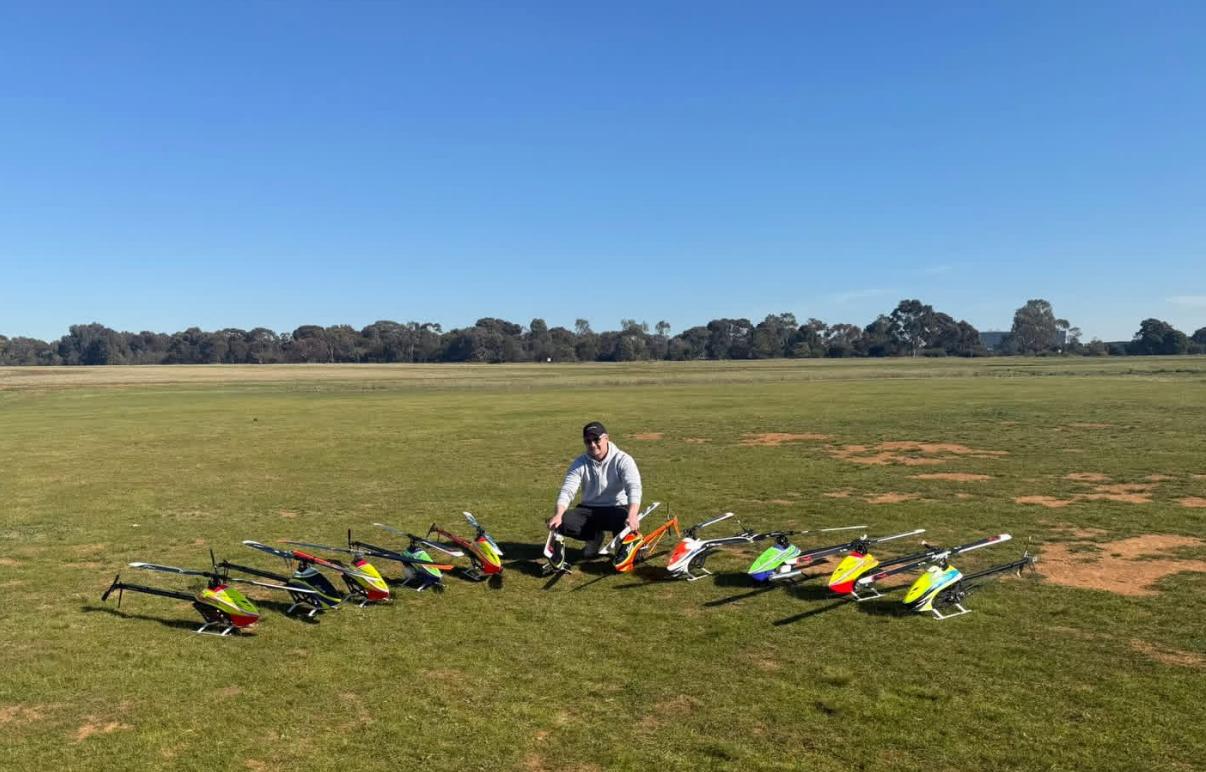 Member with a lineup of colourful helicopters on the field