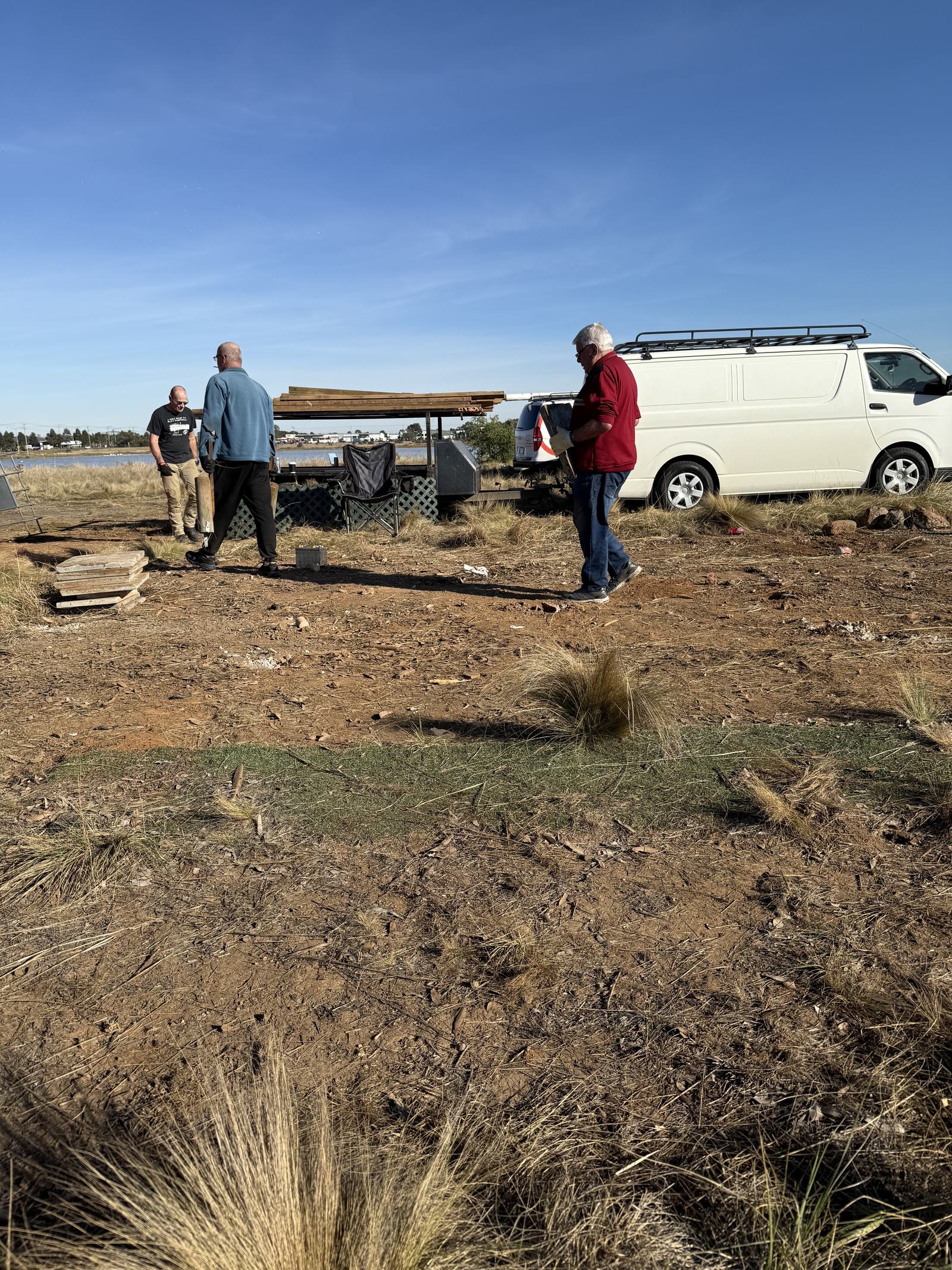 Members packing up timber and equipment during the site cleanup